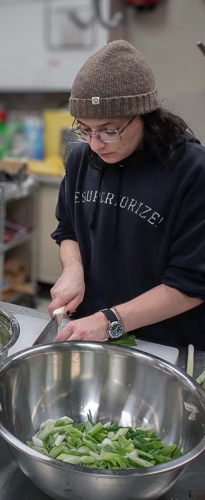 Soul Kitchen volunteer chopping veggies